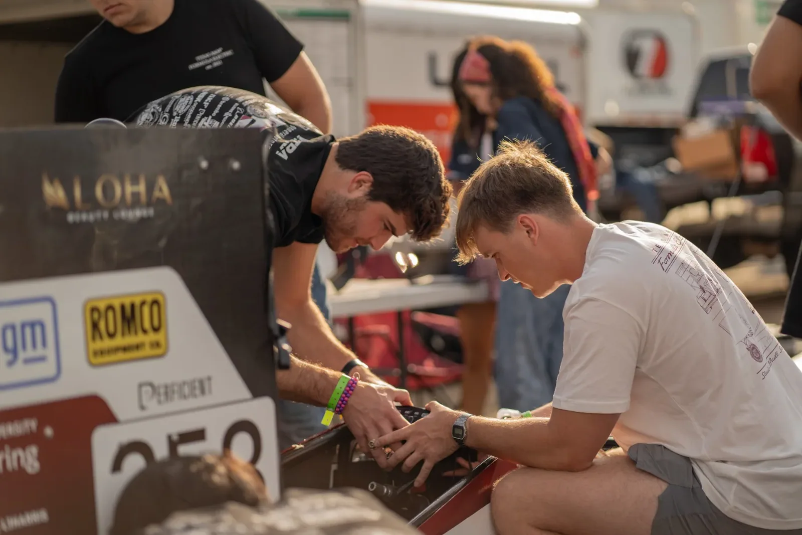 Engineers working on the side of the car in the paddock