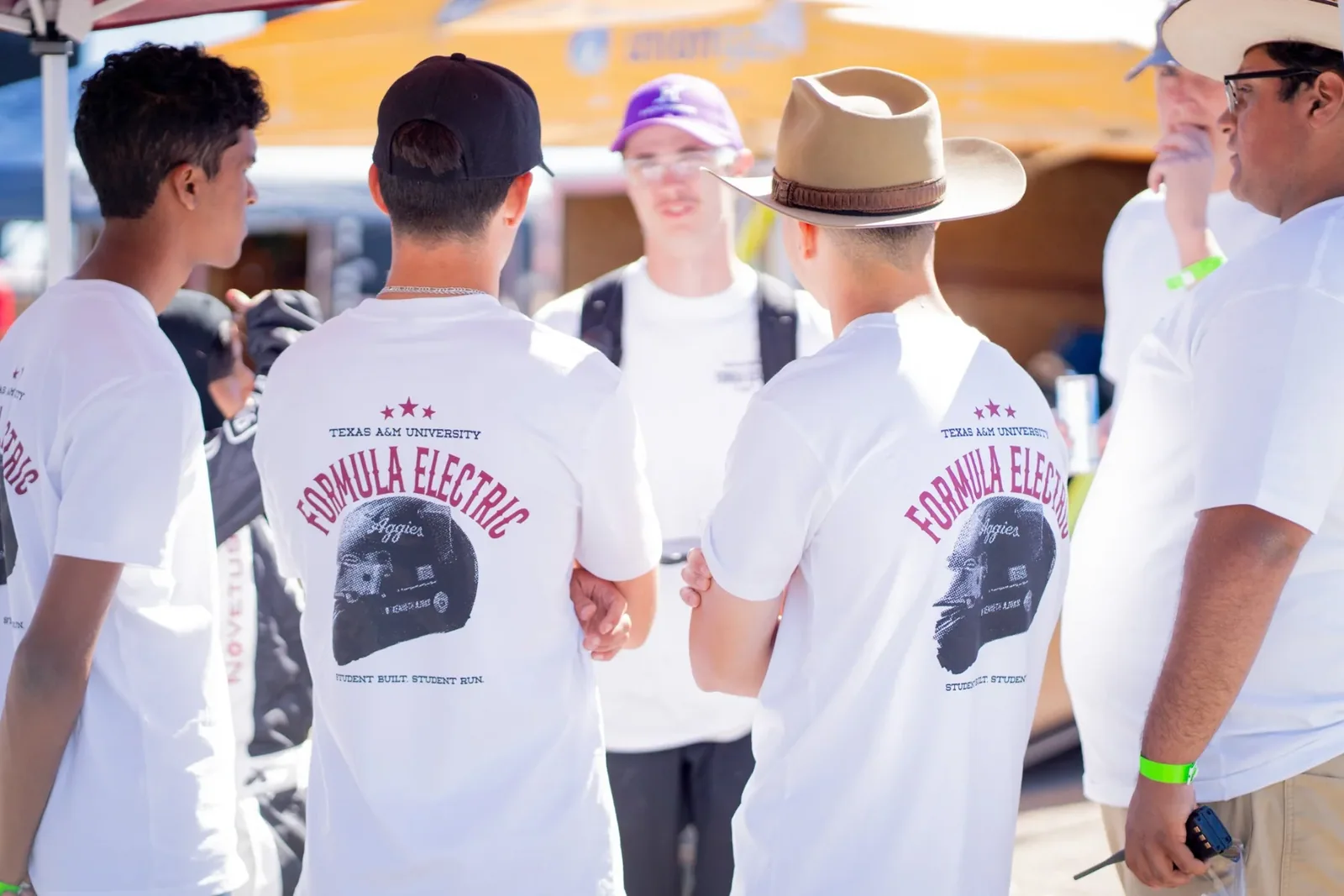 Team members in white Formula Electric helmet shirts