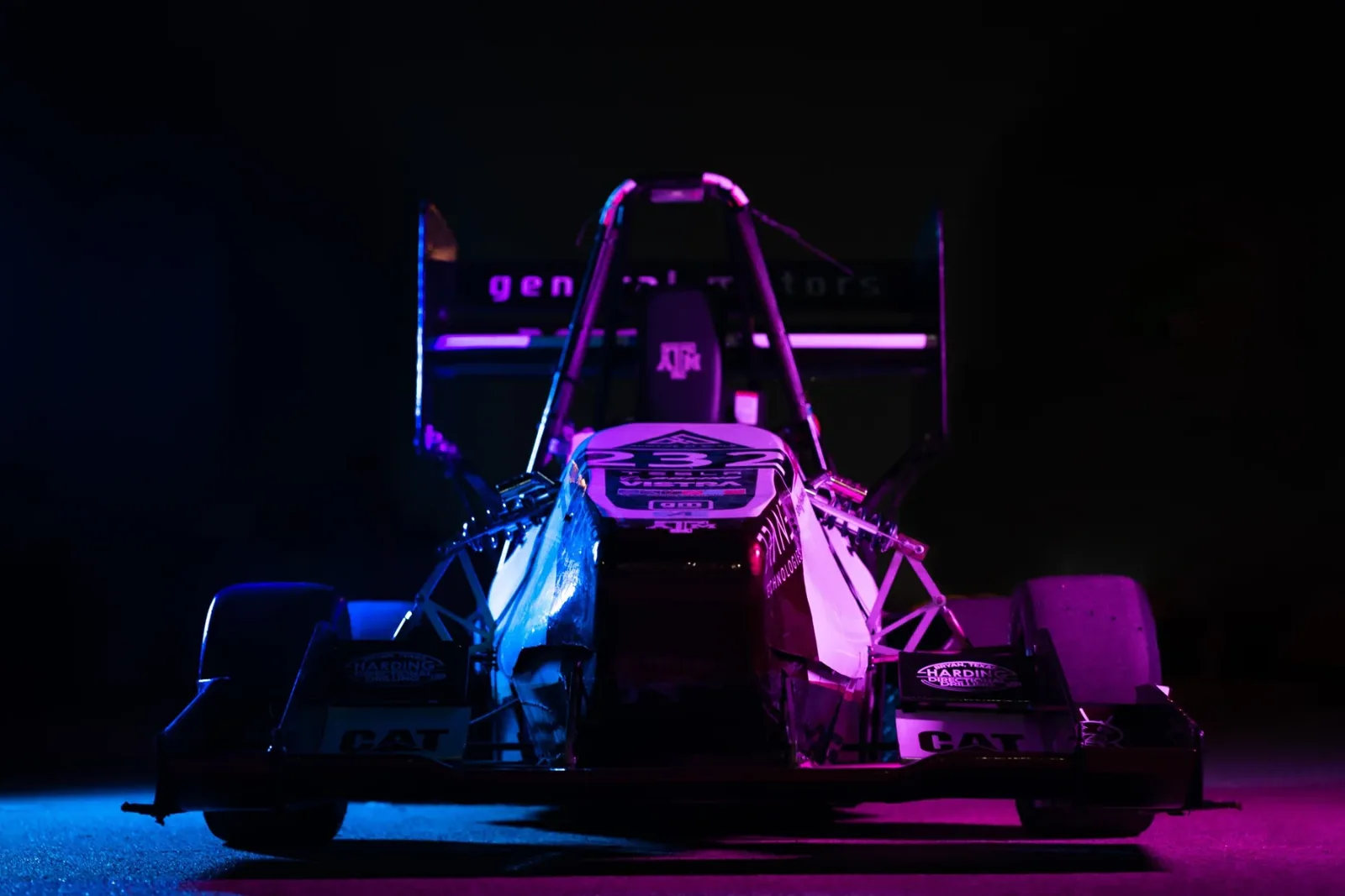 The car lit in purple and blue studio light