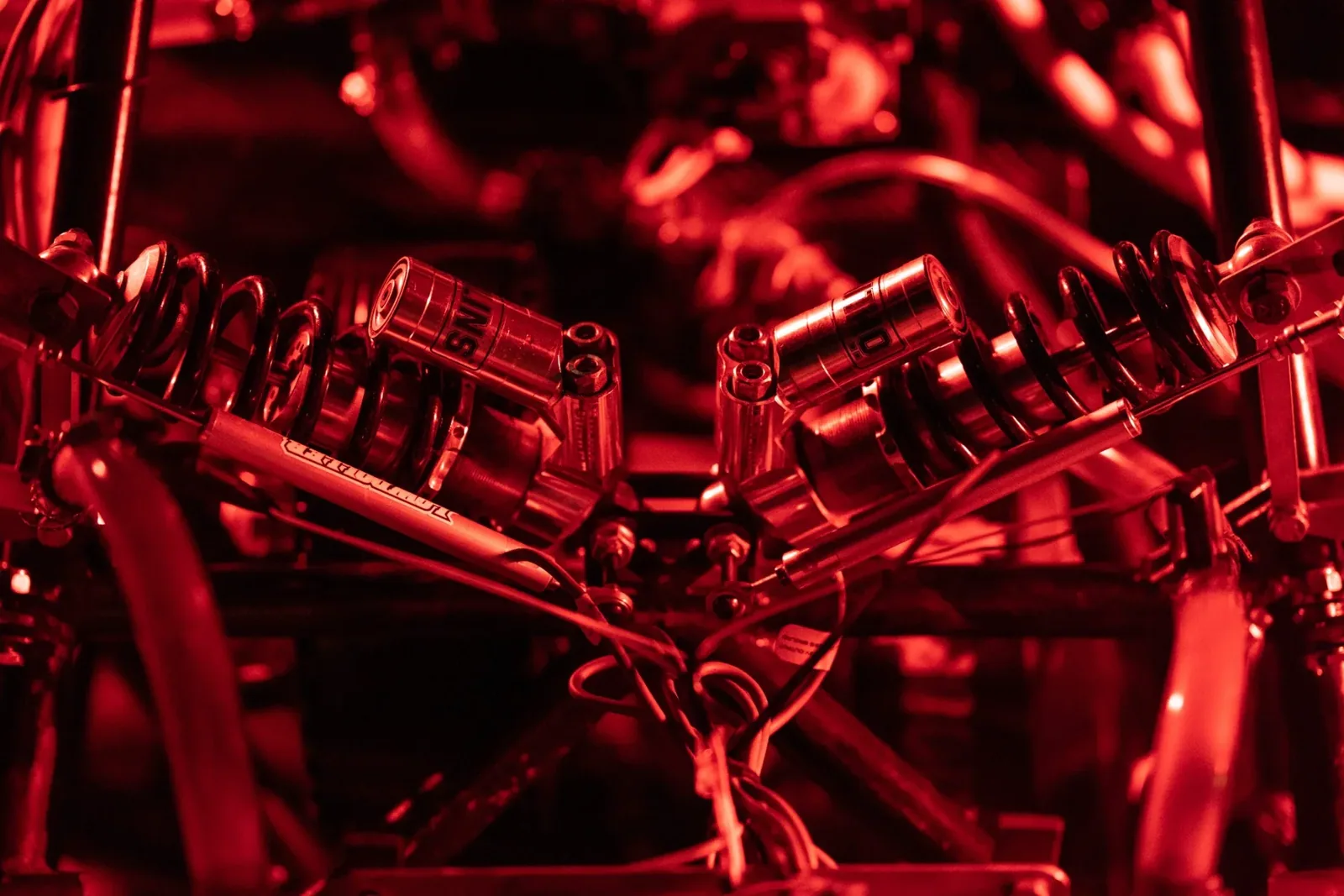 Red-lit detail of the car’s suspension and frame