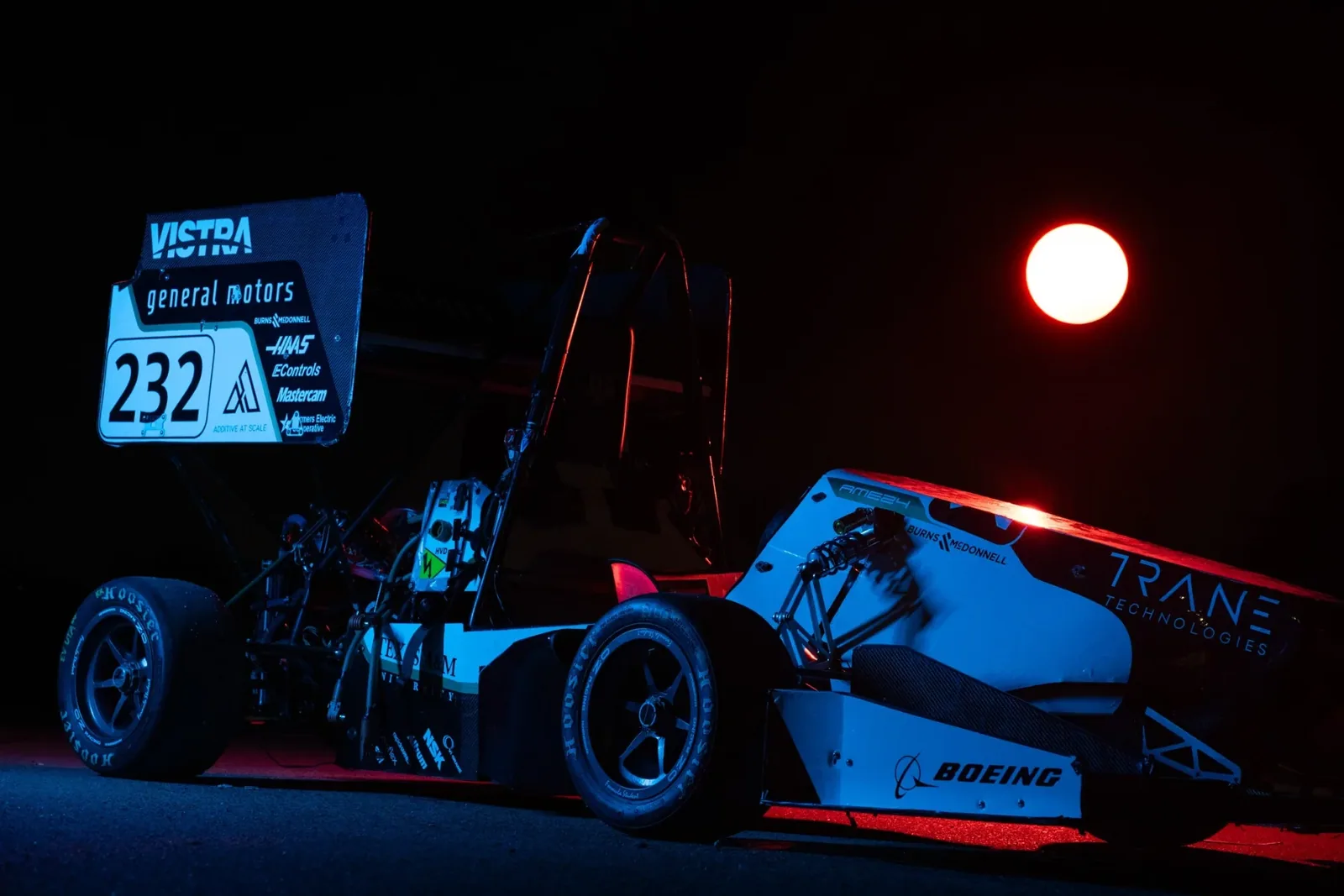 Rear three-quarter view of car 232 in blue light with a glowing lamp behind
