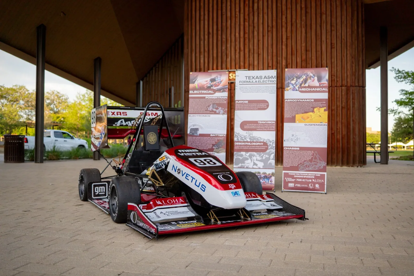 The car on display at Rollout in front of the three banners