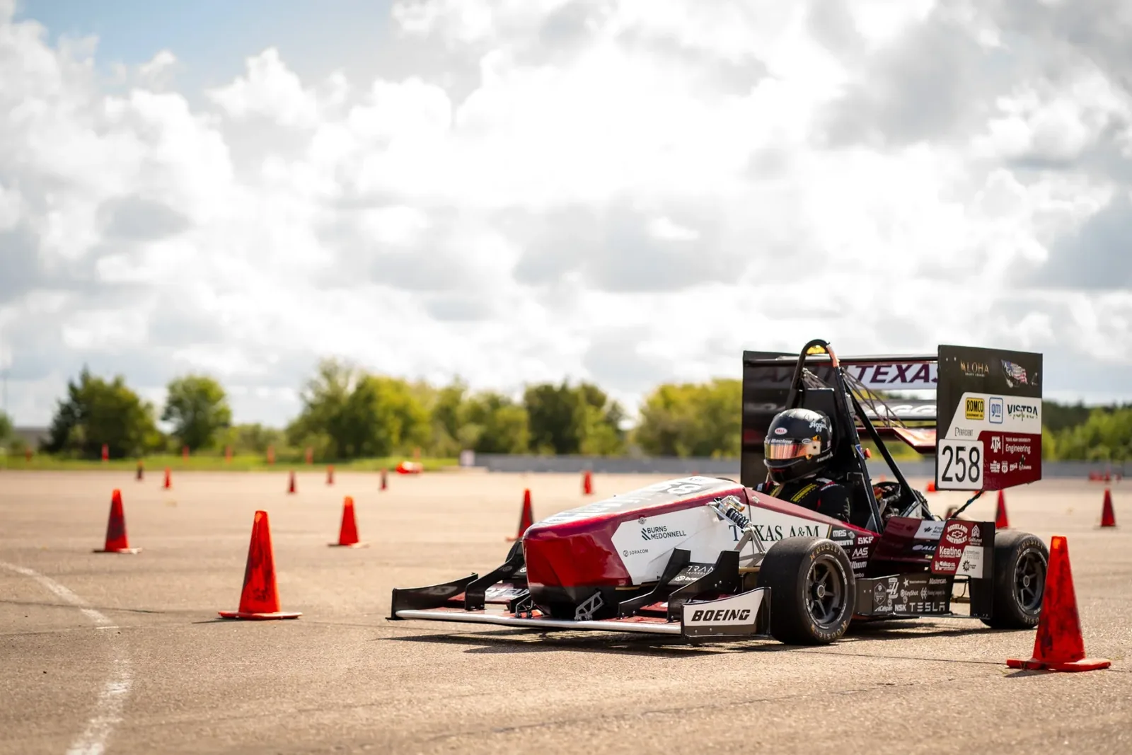 The car turning around cones on an open test lot