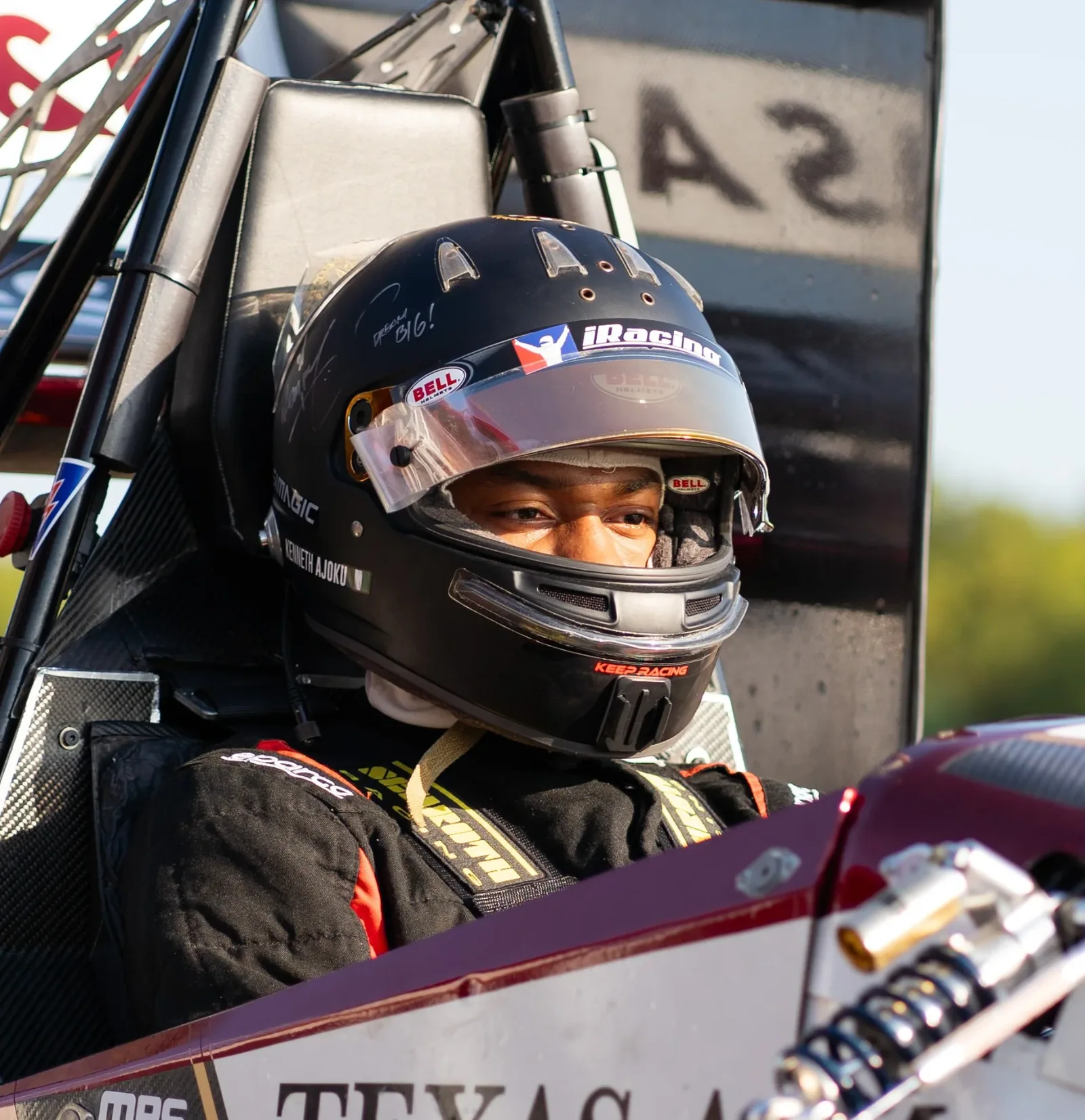Close up of the driver in the cockpit with the visor up