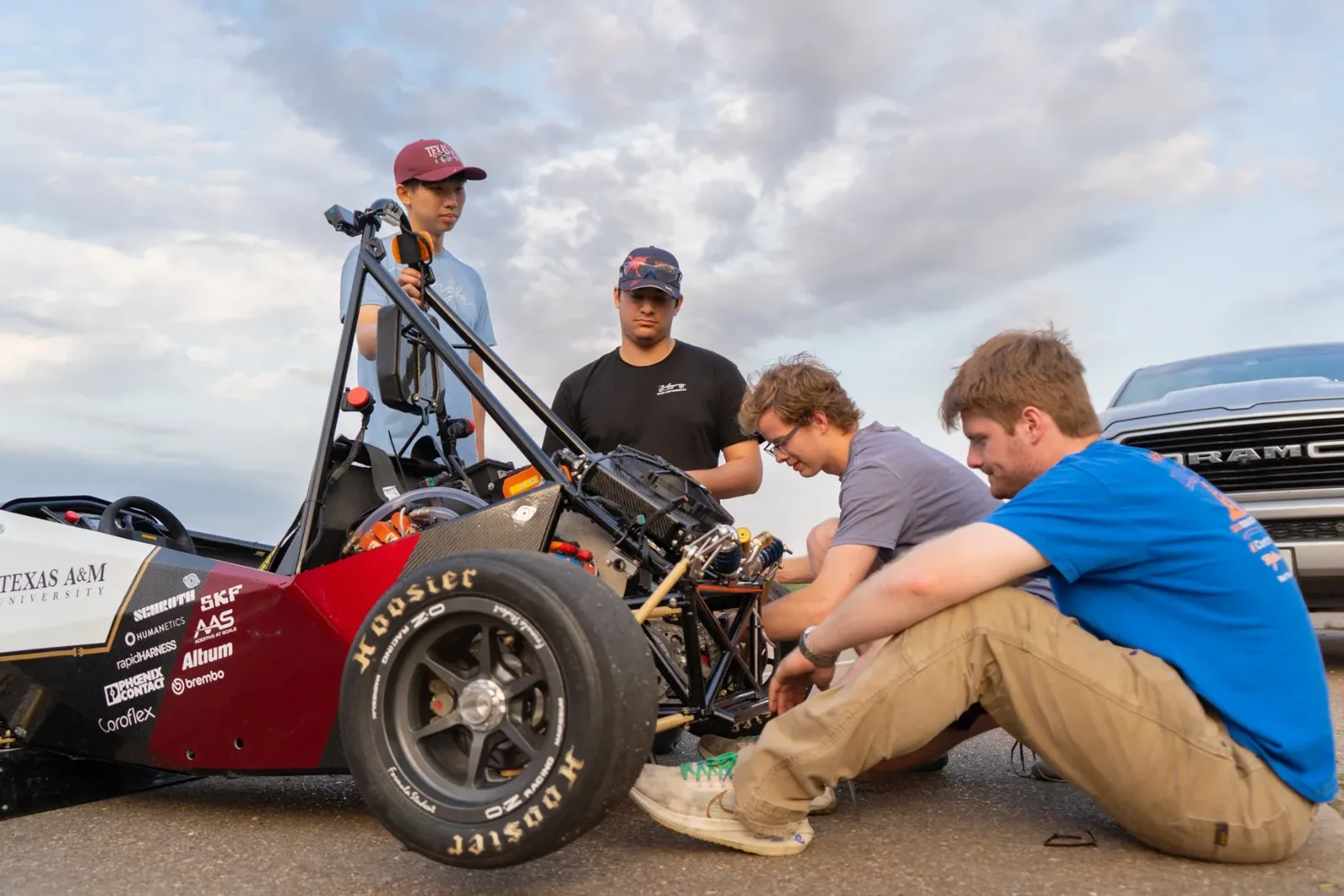 Engineers sitting, working on the rear of the car